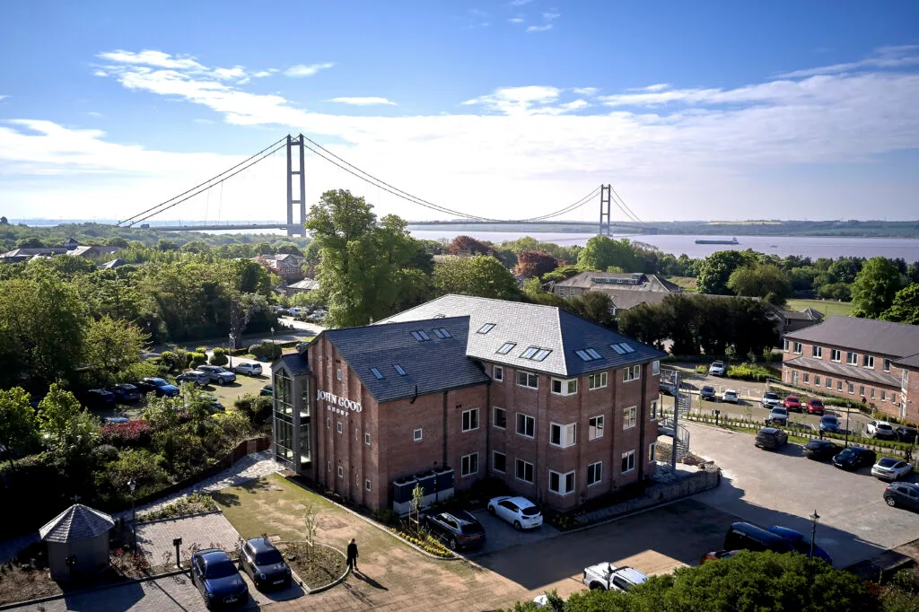 Quarry House Image taken from a height, overlooking Hesslewood Office Park. Showing a 3 story office, parkland and trees, and the Humber Bridge in the background