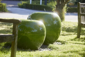 2 large apple style sculptures on grassland