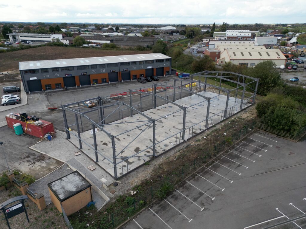 Drone view of an industrial unit under construction. Shows concrete foundations and steel pillars