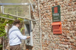 side view of man using ATM