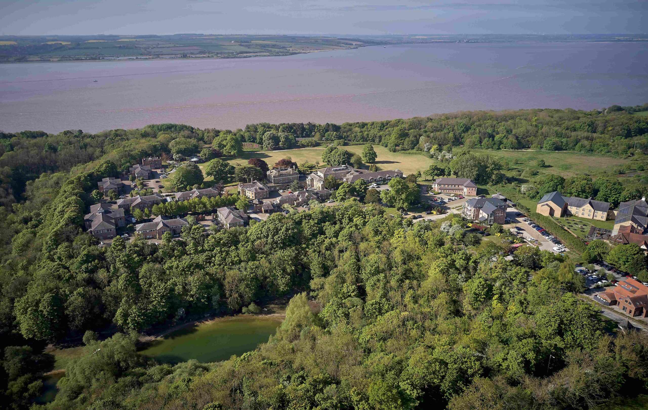 Drone view of Hesslewood Office Park, showing offices, parkland, and the River Humber in the distance