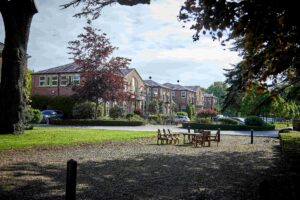 view across gravelled and grassed parkland of brick built office buildings