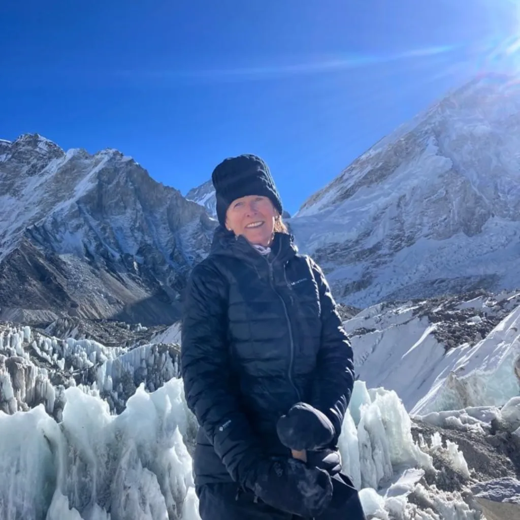 Woman dressed in winter clothing, with snow covered mountains in background