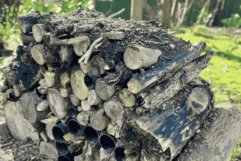 A wildlife habitat log pile at Hesslewood Office Park, providing natural shelter for insects and small creatures as part of the park's commitment to nature